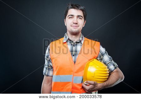 Handsome Constructor Holding Hardhat And Smiling