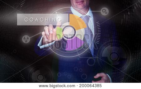 A Businessman Selecting A Coaching Button On A Computerised Display Screen.