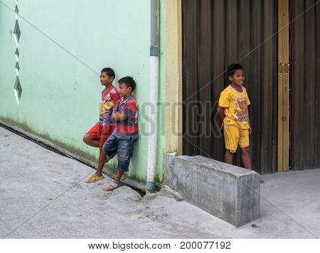 BERASTAGI INDONESIA 15 MAY 2017 : Three indonesian children near the wall on the street at countryside area of Berastagi city Northern Sumatra.