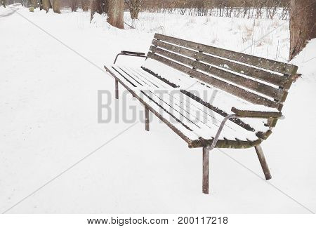 Lonely old wooden bench at snowy environment in Brunevang Rodovre Denmark