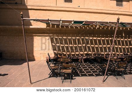 Horizontal picture of tables and chairs inside of Mehrangarh Fort on the top of the city of Jodhpur the blue city of Rajasthan in India.
