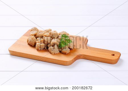 pile of soy meat cubes on wooden cutting board