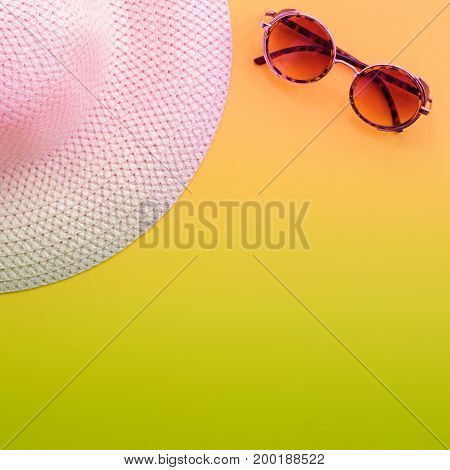Hat and sunglasses on yellow background. Summer holiday and travel concept. Copy space background top view flat lay overhead. Toned