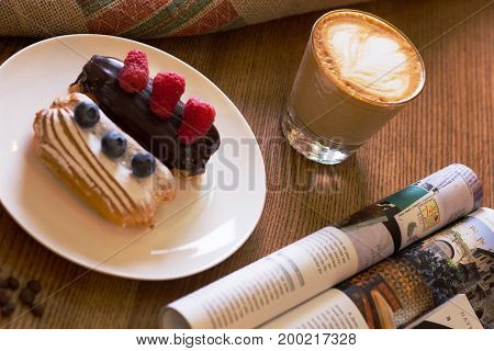 Cappuccino cake with berries and a journa on table. Top view.