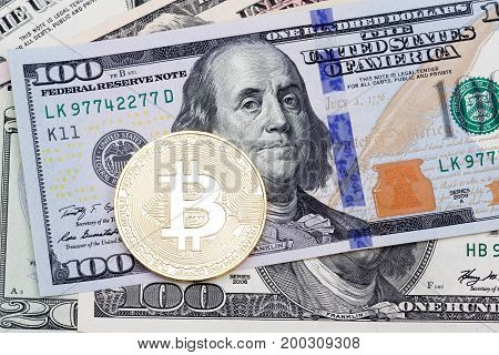 Golden bitcoin on hundred banknotes background. High resolution photo. High resolution photo.
