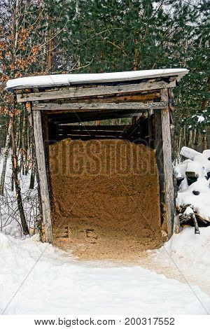 Old barn with sawdust in the winter yard