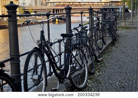 Bicycle Parking At People Stop And Lock Bike At Riverside Of Spree River At Berlin City