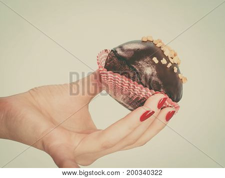 Woman Holding Chocolate Cupcake About To Bite