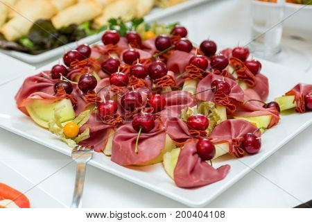 Fruits on a buffet table. Cherry with pineapple.
