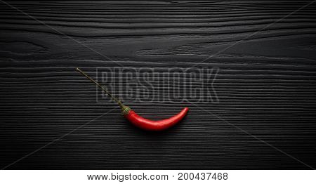 Red chili pepper on black wooden background