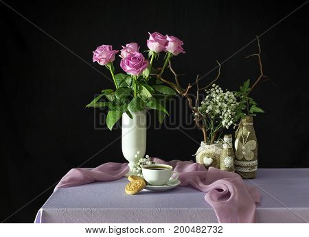 Still life with pink roses and coffee on a table close-up