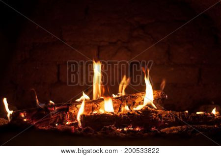 Small fire in the oven against a brick wall background