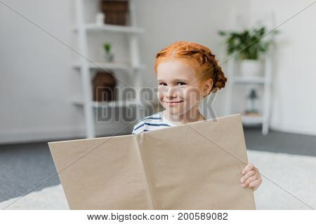 beautiful little girl smiling and holdind book