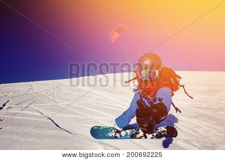 Snowboarder with a kite on fresh snow in the winter in the tundra of Russia against a clear blue sky. Teriberka, Kola Peninsula, Russia. Concept of winter sports snowkite.