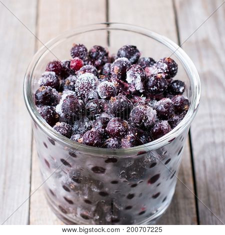 Frozen currants on a wooden background, frozen food