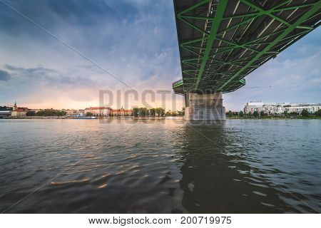 By the River under the Bridge. Skyline of Bratislava Slovakia at Sunset in Background.
