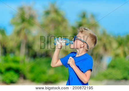 Portrait Of A Thirsty Handsome Boy In Sunglasses Drinking Water On The Desert Tropical Beach