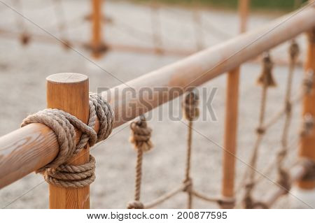 A wooden fence with tied rope at a playground