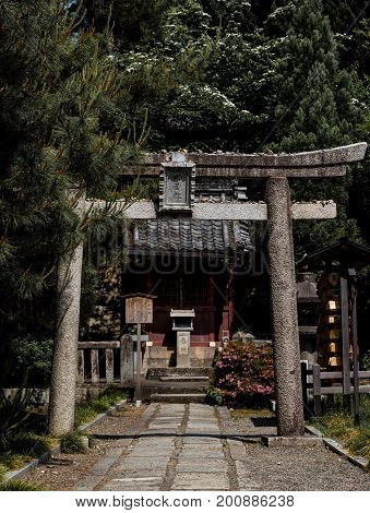 Lush greenery around Shinto Buddhist shrine Torii in Kyoto, Japan