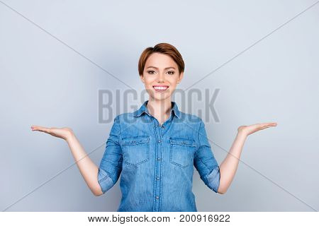 Pretty Young Lady In Jeans Shirt Asking To Make A Choice Between Two Products On Her Palms