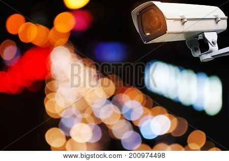 CCTV security camera system operating record and property protection with blurred image of street traffic light in the city at night vintage color tone surveillance security technology concept