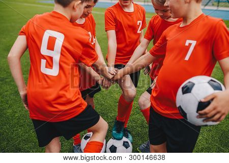 Kids On Football Soccer Team Putting Hands In. Boys Football School Team Huddling. Children Hands To