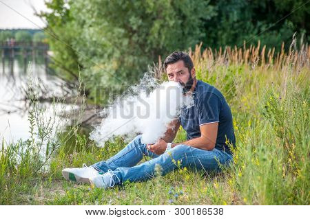 Stylish Brutal Smoker Smoking An Electronic Cigarette In The Daylight. Non-tobacco Smoking.