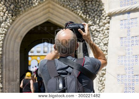 Cintra. The Pena Palace. Adult Man Takes Pictures Of The Arch On A Professional Camera. The Man Is D