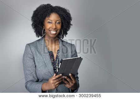 Black African American Teacher Or Businesswoman Sitting And Holding A Tablet Computer.  The Confiden