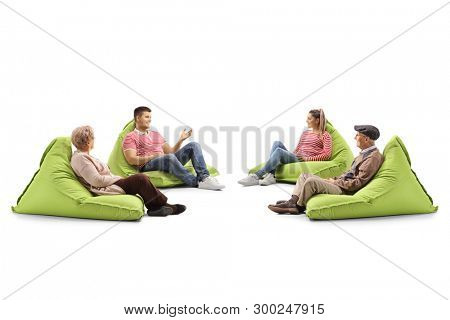 Young and senior people sitting on bean bag chairs and talking isolated on white background
