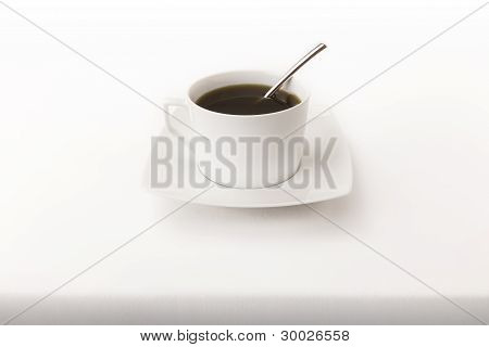 Kopje thee met een lepel op een wit tafellaken