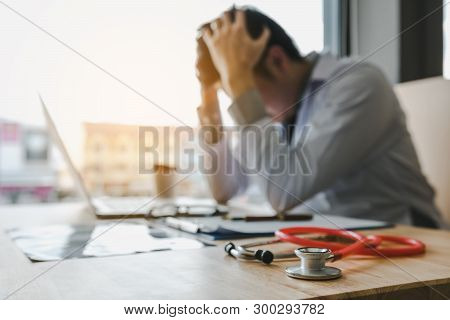 Young Man Doctor Being Exhausted In The Office Room.