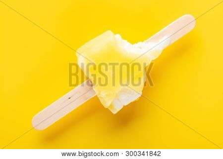 Top View Yellow Popsicle With Bites On A Yellow Background