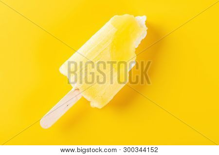 Top View Yellow Popsicle With Bites On A Yellow Background