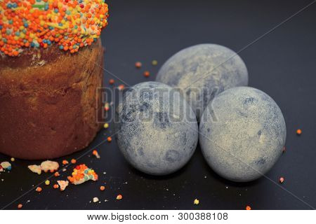 Easter Cake With Glaze, With Eggs Colored By Carcade Tea On A Black Background In A Beam Of Light, A