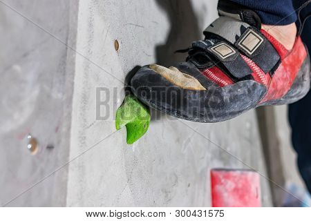 Rocky Shoe On A Tiny, Scanty Snare Stands With The Tip Of The Sock In Close-up On The Climbing Wall 