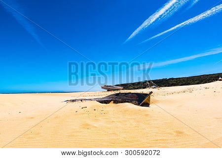 Wooden Boat Abandoned On A Beach For The Future Memory Of A Desertification That Moves Inexorably