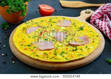 Omelet With Ham, Cheese, Greens On A Wooden Board On A Black Background.  Fritata - A Delicious, Hea