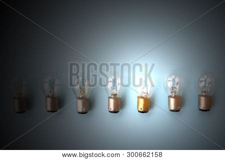 Row Of Switched Off Light Bulbs With One Switched On. Concept Of Having Idea And Creativity