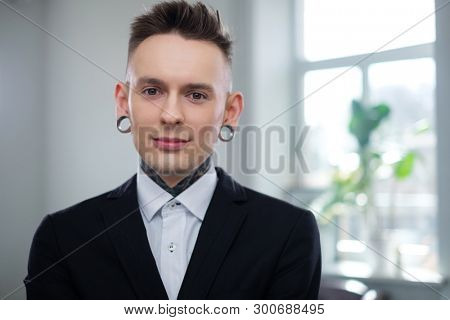 Portrait of alternative model with earplugs and tattoo