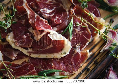 Hamon.tasty Ham Sliced ​​into Strips On A Wooden Background With Spices And Fresh Thyme. A Serving O