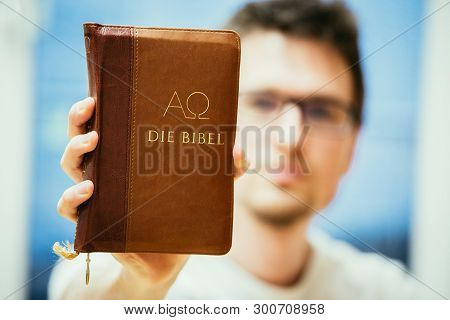 Christian Preacher: Young Man Is Holding The Bible, Praying
