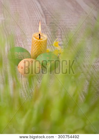 Burning Beewax Candle, Easter Eggs Behind Fresh Spring Grass, Text Space