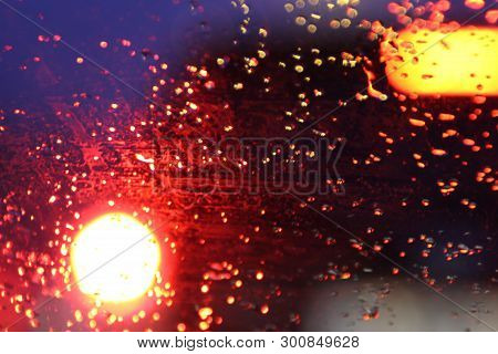Traffic Is Viewed Through The Car's Windshield Covered In Rain, . Beautiful Background Of Rain And L