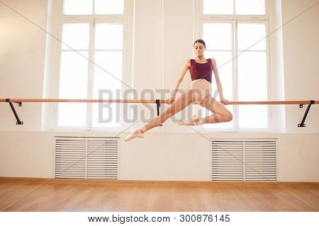 Concentrated Strong Beautiful Young Ballerina In Pointe Shoes Doing Elegant Pull-up On Barre In Ball