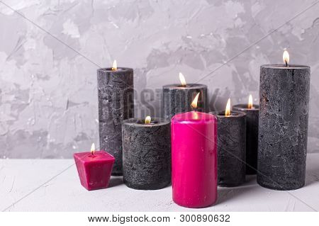 Black And Red  Burning Candles  On Grey Textured Background. Spa Or Still Life Concept. Selective Fo