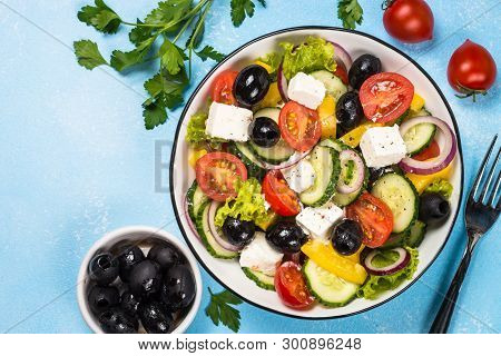Greek Salad. Vegetable Salad From Tomato, Cucumber, Feta Cheese And Olive Oil. Top View On Blue Back