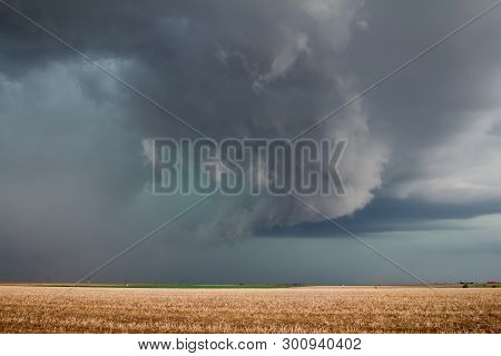 A Severe Supercell Storm Containing Rain, Hail, And Damaging Winds Approaches Over Farmland.