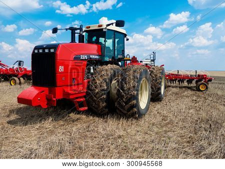 DECABRIST VILLAGE, SARATOV REGION, RUSSIA - 28 APRIL 2019: Sowing works on the wheat field. Planting complex - tractor and seeder mechanism