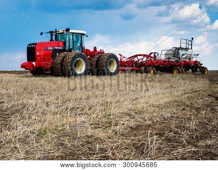 DECABRIST VILLAGE, SARATOV REGION, RUSSIA - 28 APRIL 2019: Sowing works on the wheat field. Planting complex - tractor and seeder mechanism